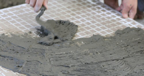 man applies ceramics to tile 